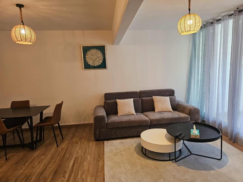 a living room with a couch and a table at T2 cosy avec place de parking in Mamoudzou
