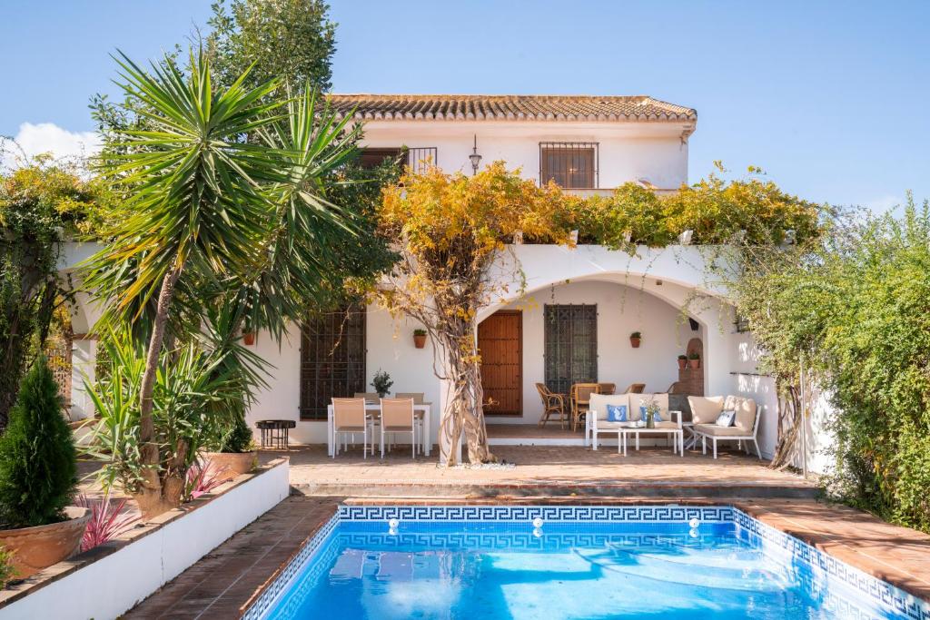 a villa with a swimming pool in front of a house at Casa rural Buenos Días con chimenea, calefacción y barbacoa in Padul
