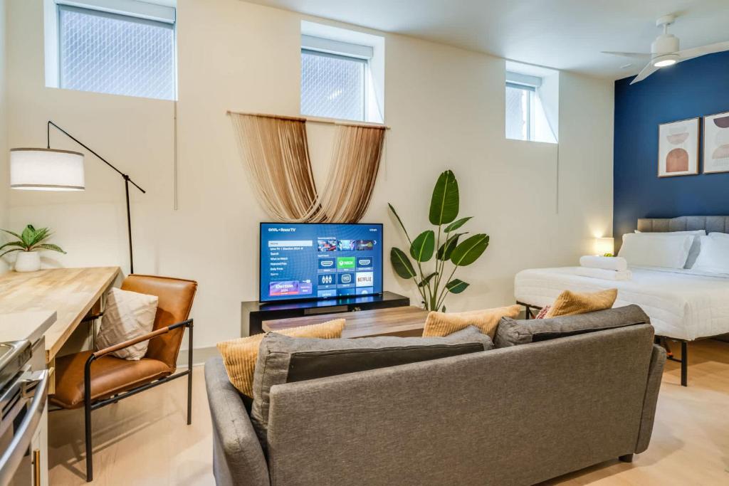 a living room with a couch and a bed at Bright and Modern Studio in Louisville # 109 in Louisville