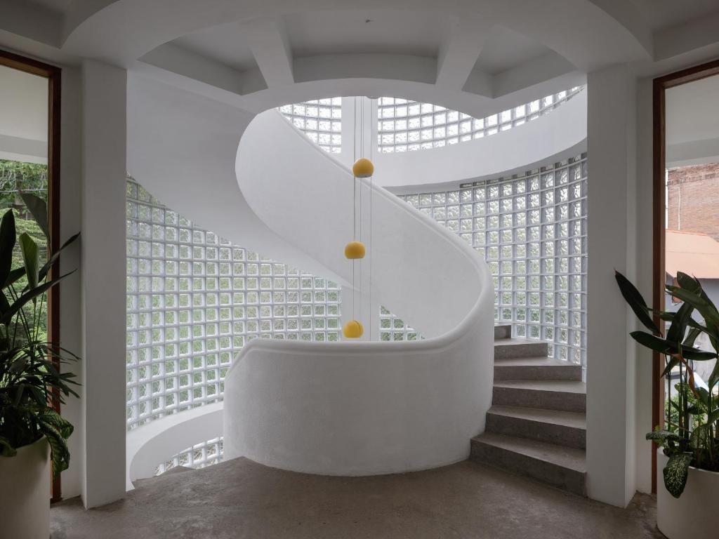 a white spiral staircase in a house with windows at Lighthouse Bingin - 360 view in Uluwatu