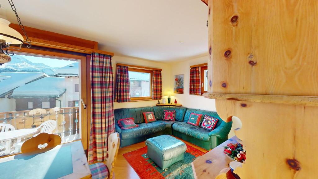 a living room with a green couch and a balcony at Apartment Ambretta OG in Champfer
