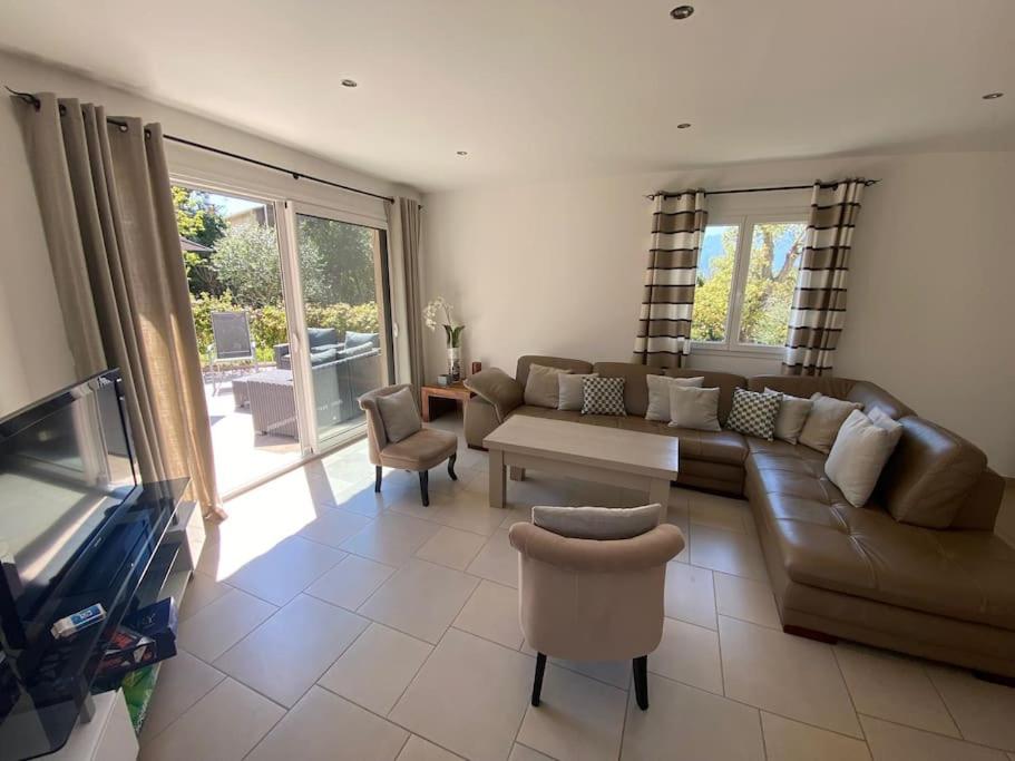 a living room with a couch and a tv at Maison jasmin Porto Vecchio in Porto-Vecchio