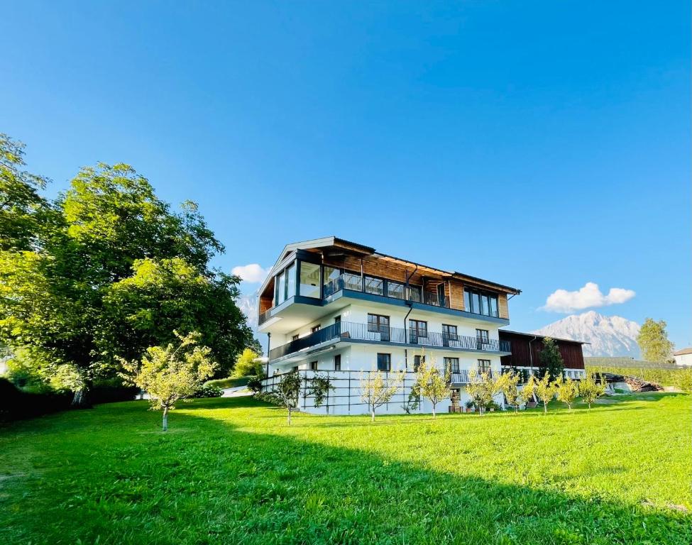 a large white building with a grassy field at Ferienwohnungen Lukaserhof in Mieming