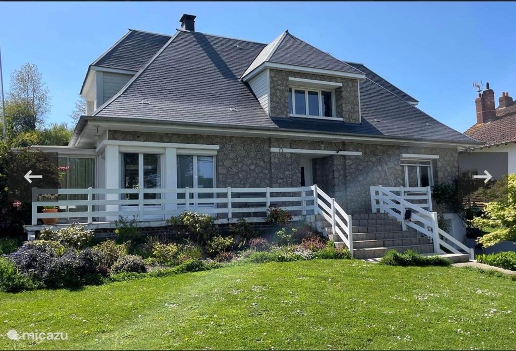 une maison avec une clôture blanche dans la cour dans l'établissement Maison Coco Quiberville sur Mer-groundfloor, à Quiberville