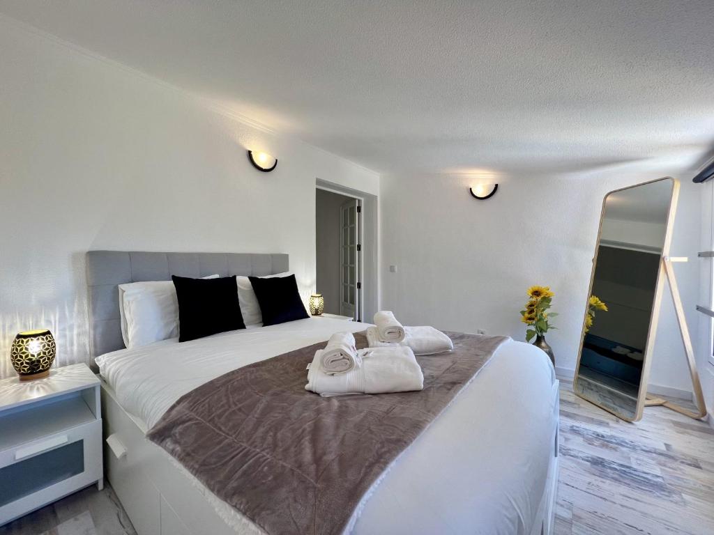 a white bedroom with two towels on a bed at Albufeira Stylish 3 by Homing in Albufeira