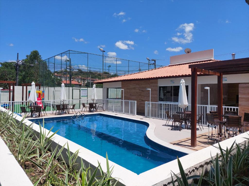 a swimming pool with chairs and umbrellas next to a building at Ótimo apartamento, bem localizado in Aracaju
