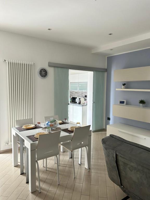une salle à manger avec une table et des chaises blanches dans l'établissement Refrésh House, à Brindisi