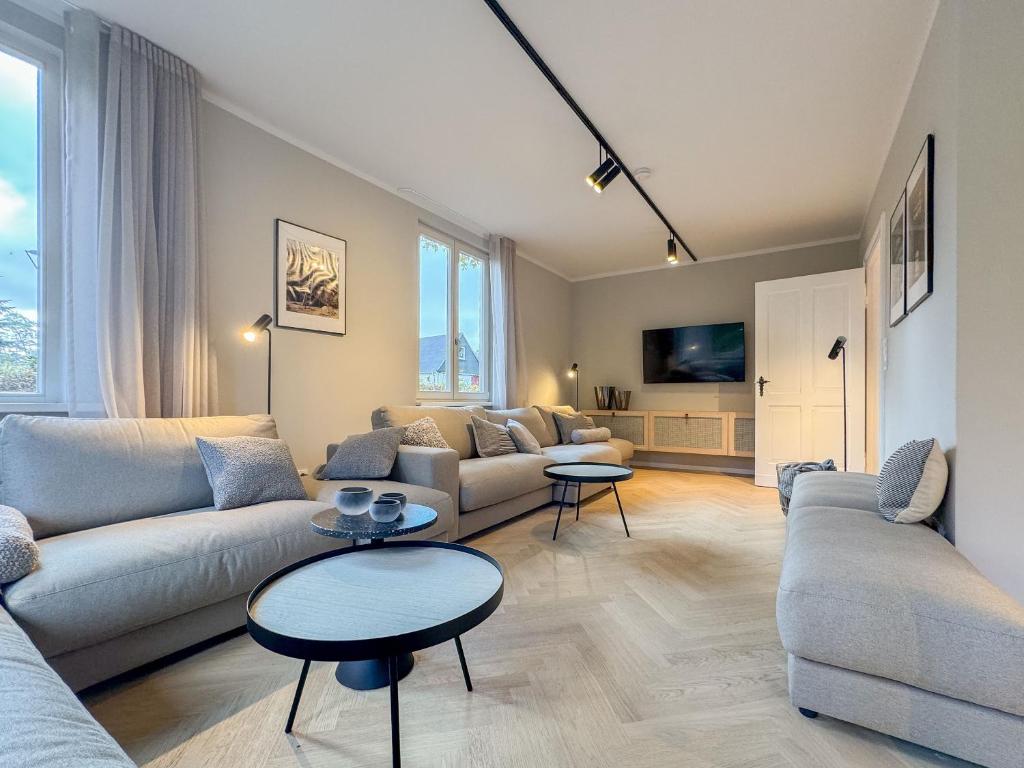 a living room with two couches and two tables at Ferienhaus Beatus ille in Kolpinsee