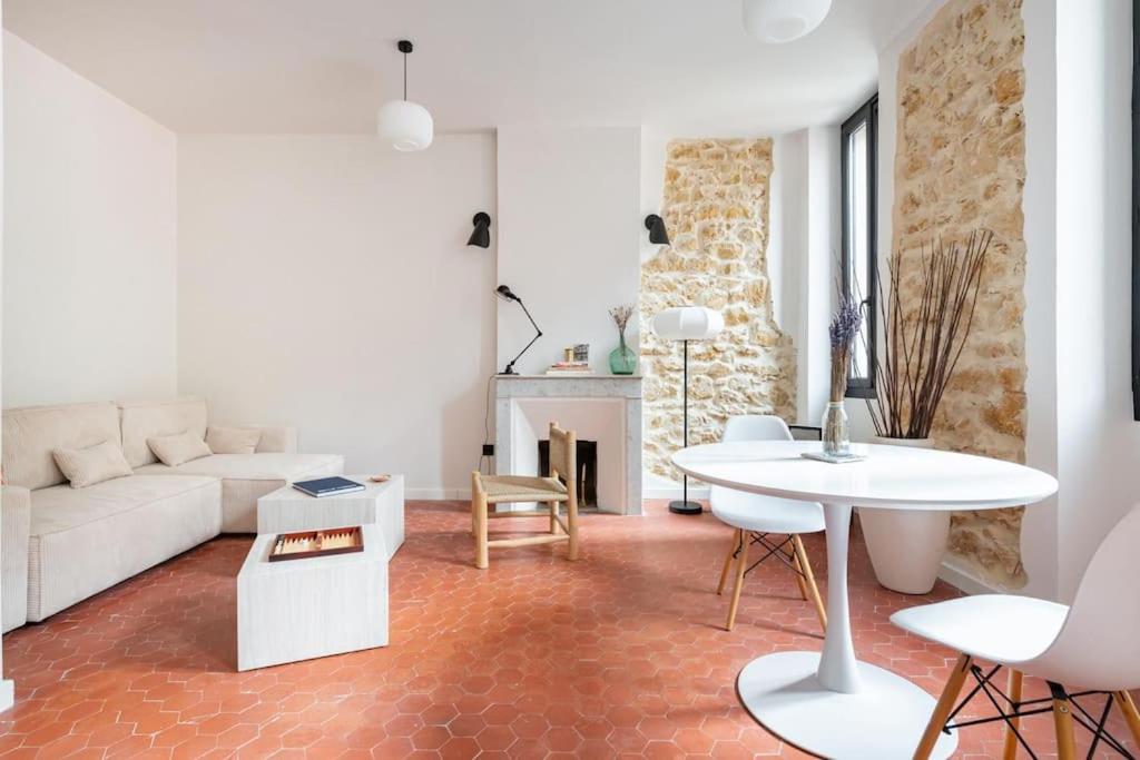 un salon avec un canapé blanc et une table dans l'établissement T2 typique et décoré avec goût - quartier Vauban, à Marseille