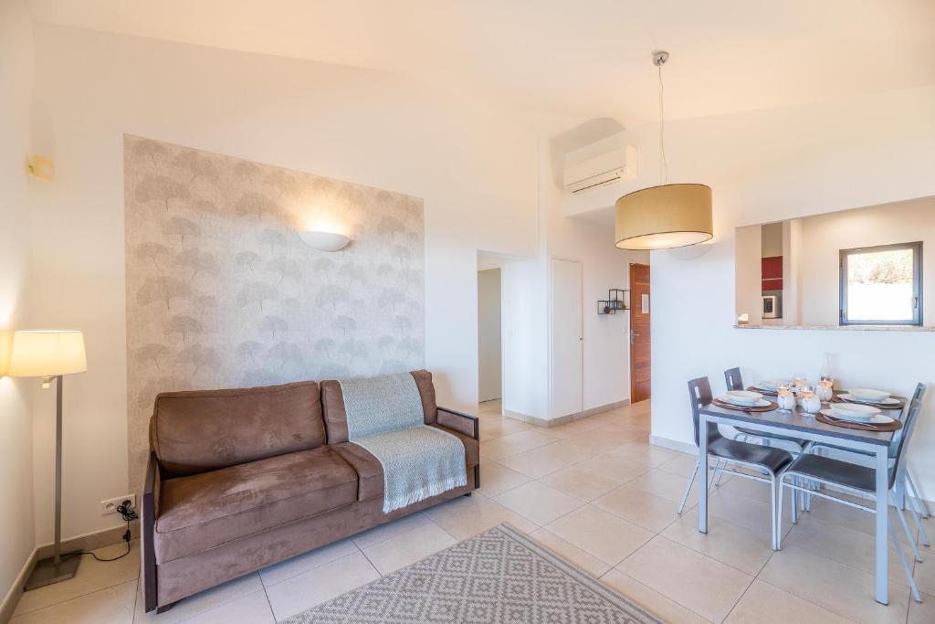 a living room with a couch and a table at Résidence Les Terrasses de Rondinara in Bonifacio