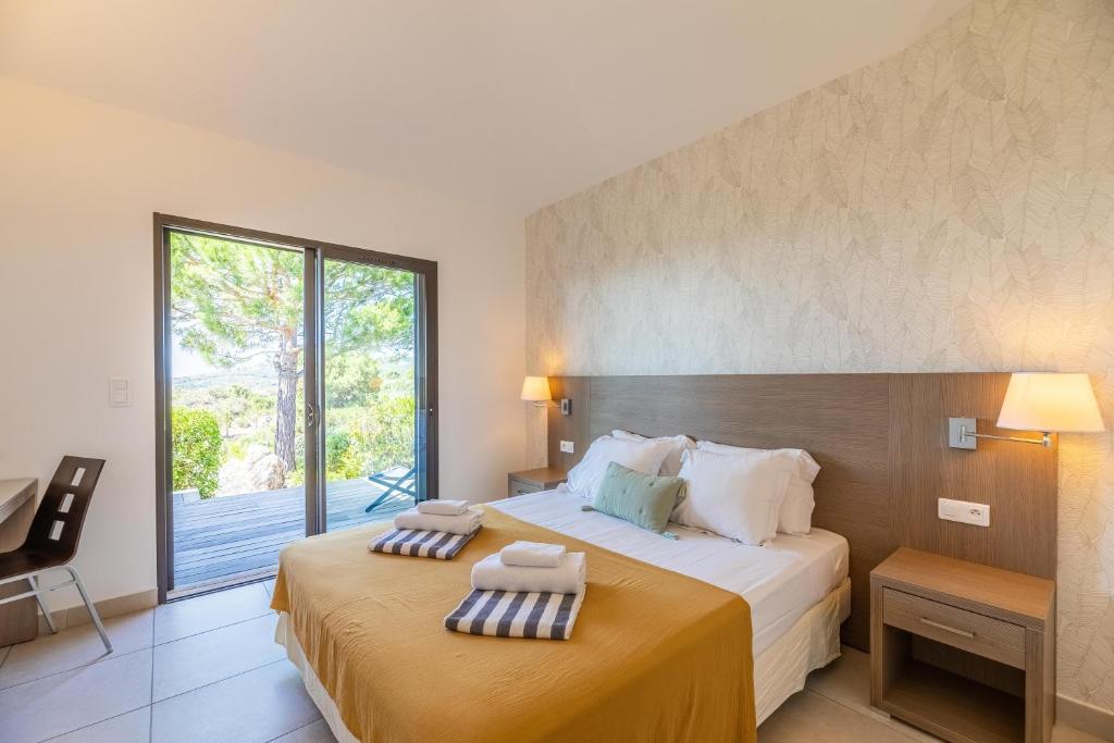 a hotel room with two beds and a balcony at Résidence Les Terrasses de Rondinara in Bonifacio
