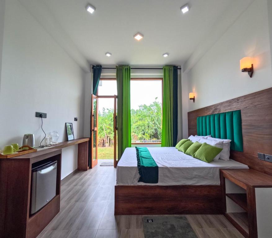 Chabee N Jay Villa Madiha Beach في ماتارا: غرفة نوم بسرير مع ستائر خضراء وتلفزيون