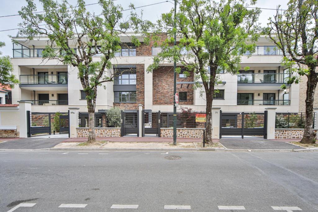 une rue vide en face d'un immeuble dans l'établissement Blue Nights Appartements 69, à Chennevières-sur-Marne