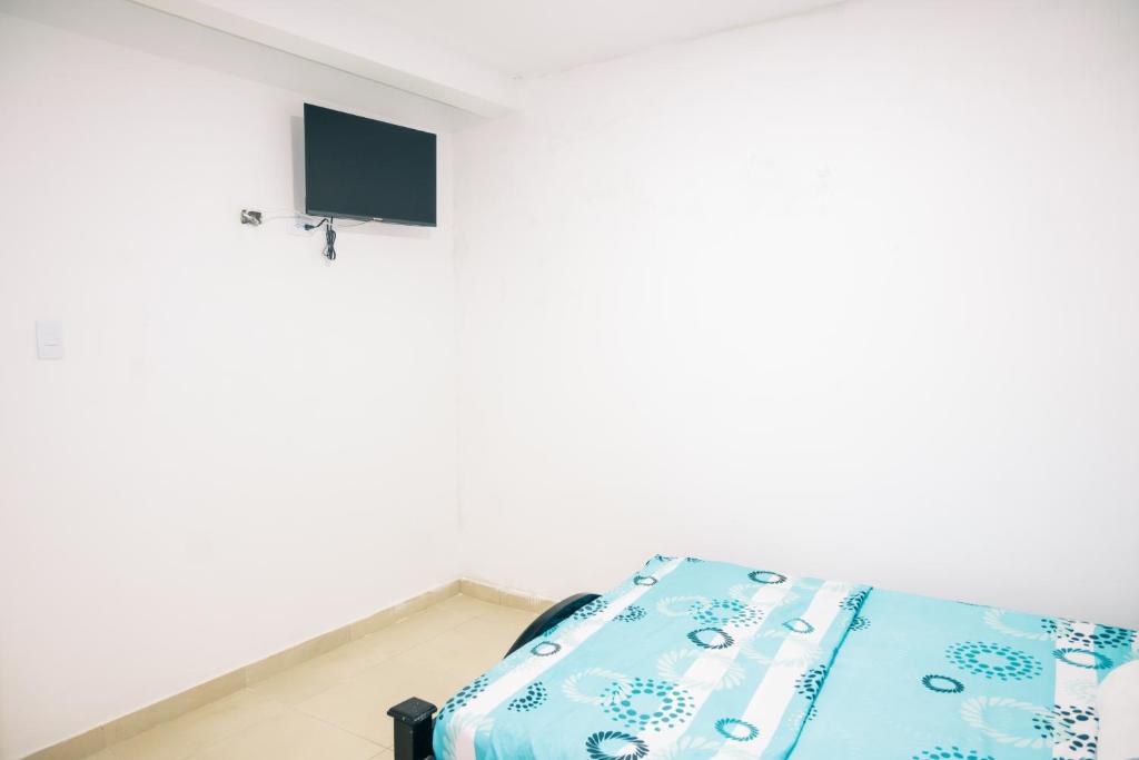 un letto in una stanza con una TV a parete di Casa Hemma a Santa Marta