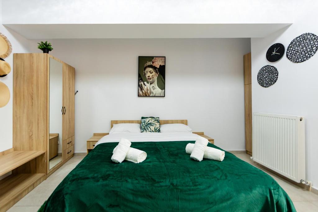 een slaapkamer met een groot bed en een groene deken bij Matei Basarab Chic Studio in Boekarest