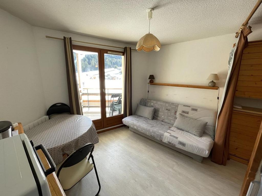 une petite chambre avec un lit et une fenêtre dans l'établissement Studio confortable proche pistes ski & commerces - FR-1-787-95, à Laveissière