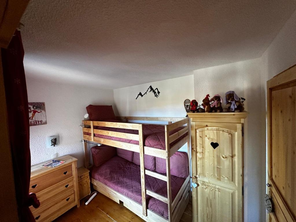 - une chambre avec des lits superposés et des draps violets dans l'établissement Appartement spacieux au cœur de Belle Plagne - 5 pers - FR-1-181-2849, à La Plagne Tarentaise