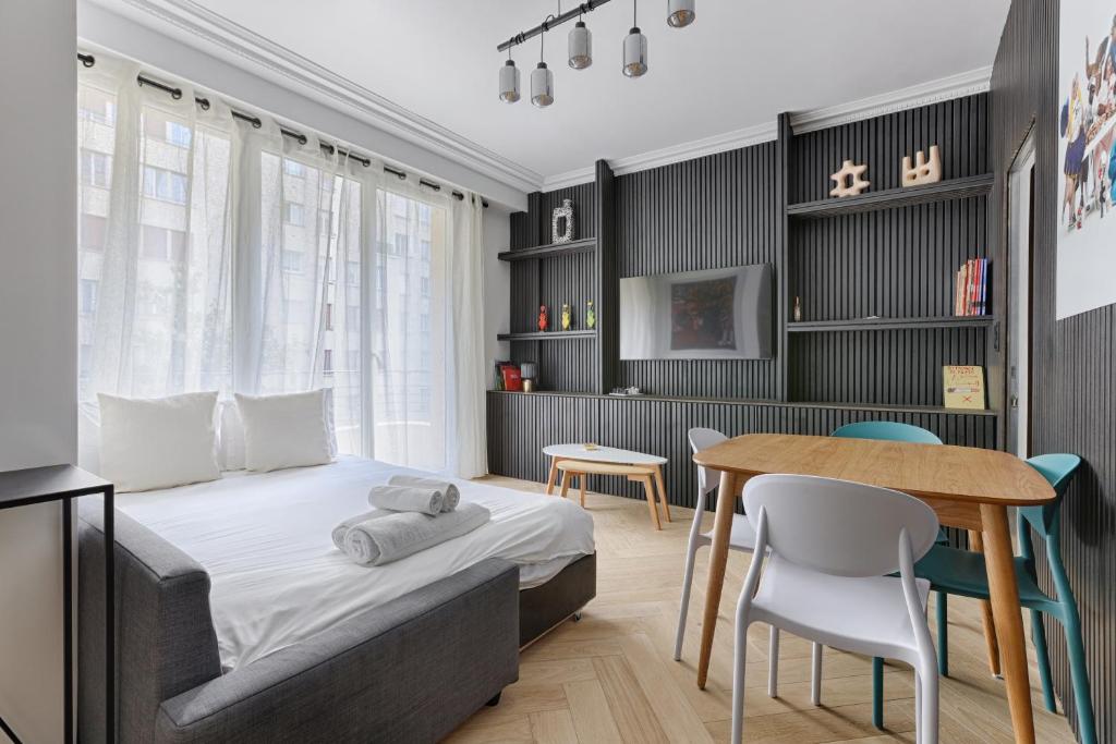 une chambre avec un lit, une table et des chaises dans l'établissement Luxury Apartment Trocadero 2BR, à Paris