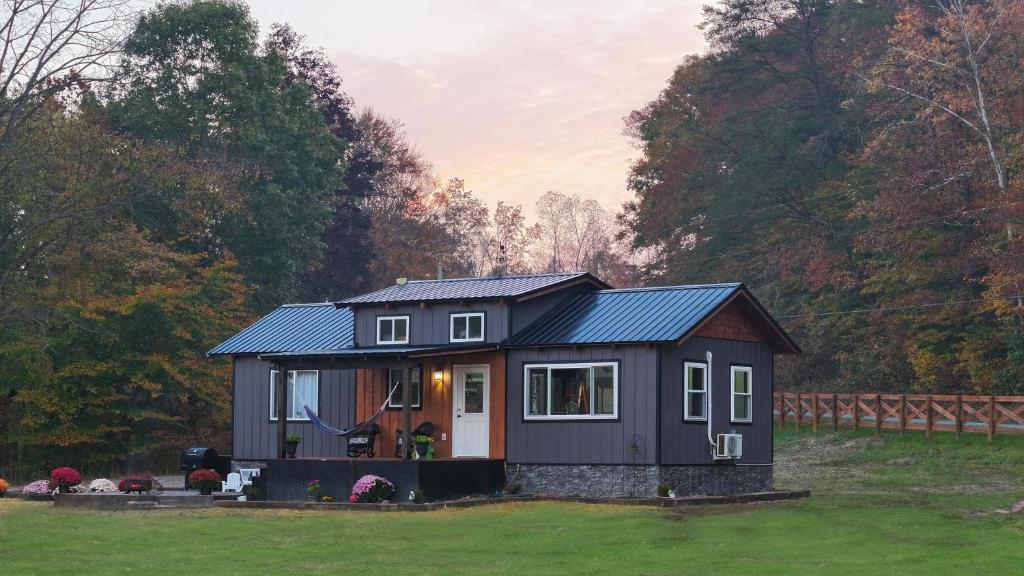 una piccola casa con un tetto blu in un cortile di Eagle Lake Cottage a Dunnville