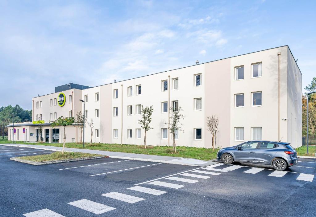 ein Auto, das auf einem Parkplatz vor einem Gebäude geparkt ist in der Unterkunft B&B HOTEL Bordeaux Saint André de Cubzac in Saint-André-de-Cubzac