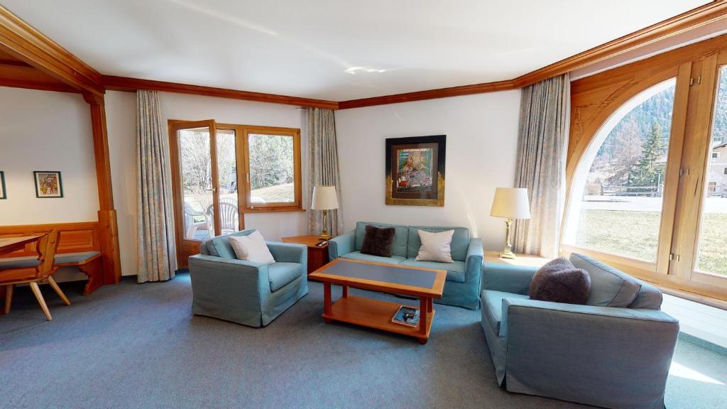 a living room with two chairs and a table at Apartment Belvair 31 in Zuoz