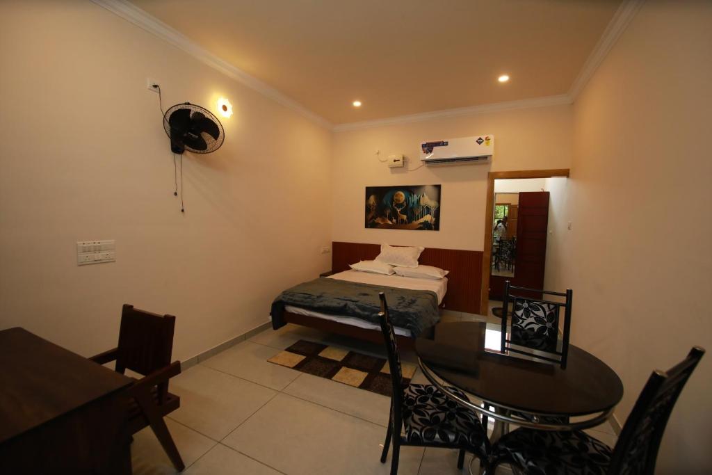 una camera da letto con un letto e un tavolo e una sala da pranzo di Star Light Residency a Munroe Island