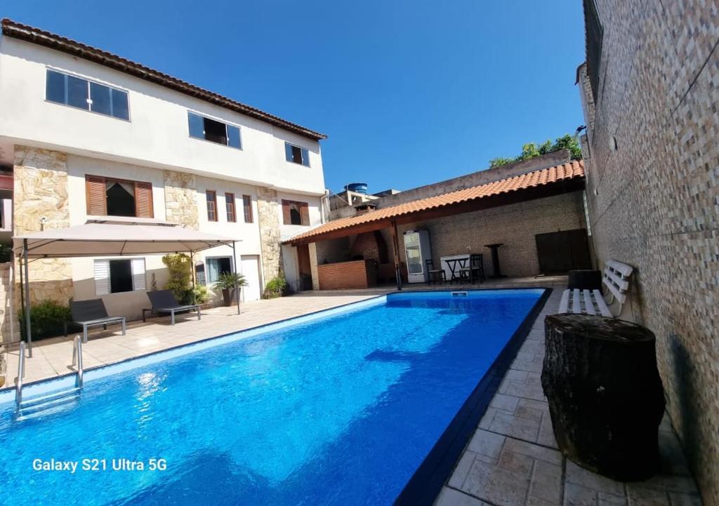 a swimming pool in front of a building at Casa com piscina e lazer em SBC SP in São Bernardo do Campo