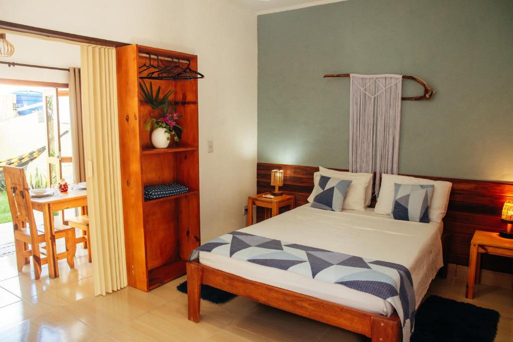 Un dormitorio con una cama y una mesa y una ventana. en Dunas Pipa acomodações, en Pipa