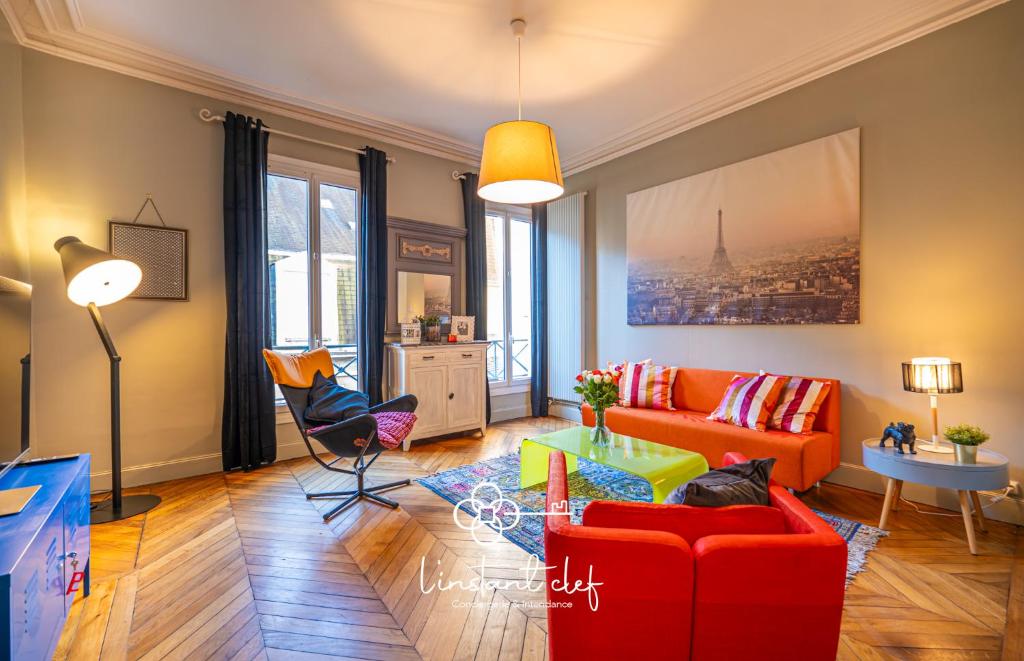 a living room with a red couch and a table at Votre cocon 5 étoiles en plein centre du Mans in Le Mans