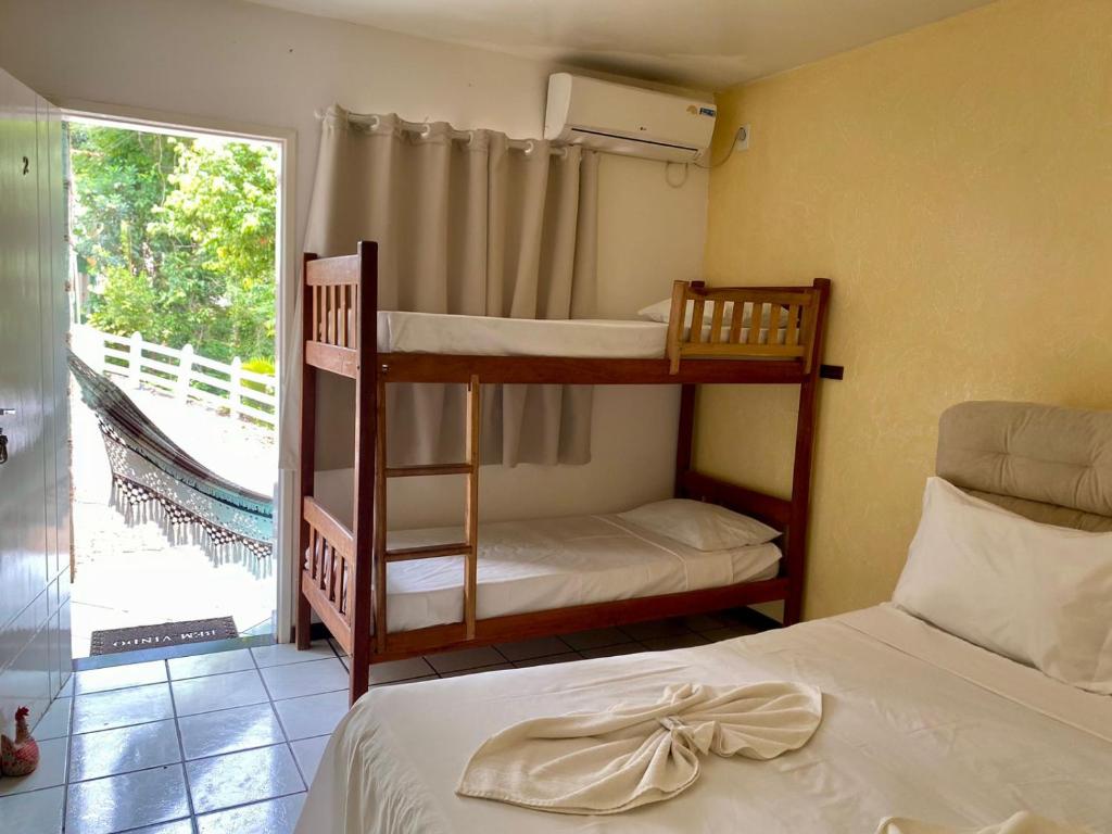 two bunk beds in a room with a window at Pousada das Arvores in Lençóis