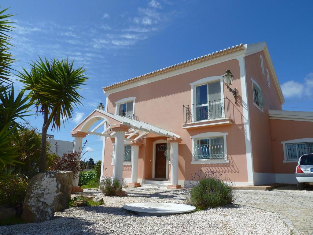 a pink house with a palm tree in front of it at Highview Villa in Lagos