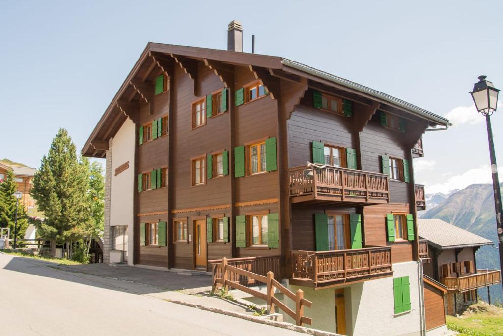 a large wooden building with balconies and a street light at Chalet Wurzenbord 1 in Bettmeralp