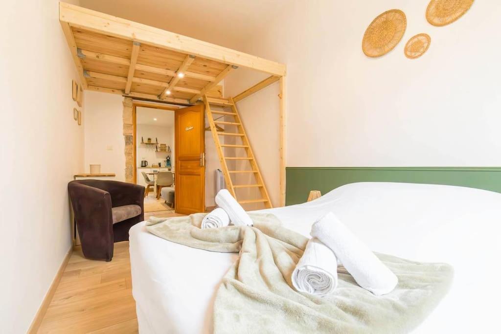 - une chambre avec un lit, une chaise et une échelle dans l'établissement Le jardin des Plantes, à Dijon