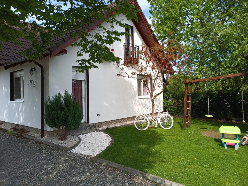 a white house with a bike parked in the yard at Casa Diana Confort in Avrig