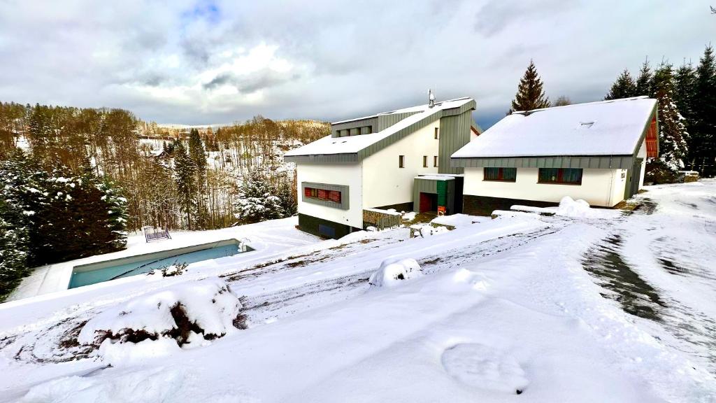 Una casa en la nieve con un coche dentro en Vista 14, en Rokytnice nad Jizerou