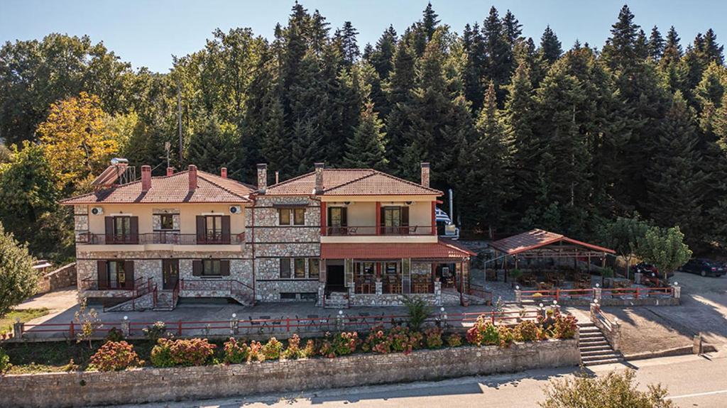 duży dom z drzewami w tle w obiekcie Guesthouse Moucha w mieście Moúcha