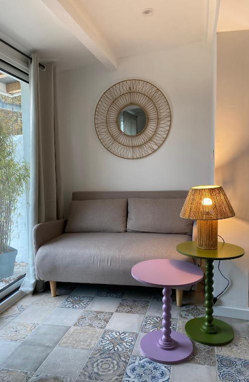 un salon avec un canapé et un miroir dans l'établissement Hameau au coeur de la foret landaise, à Herm