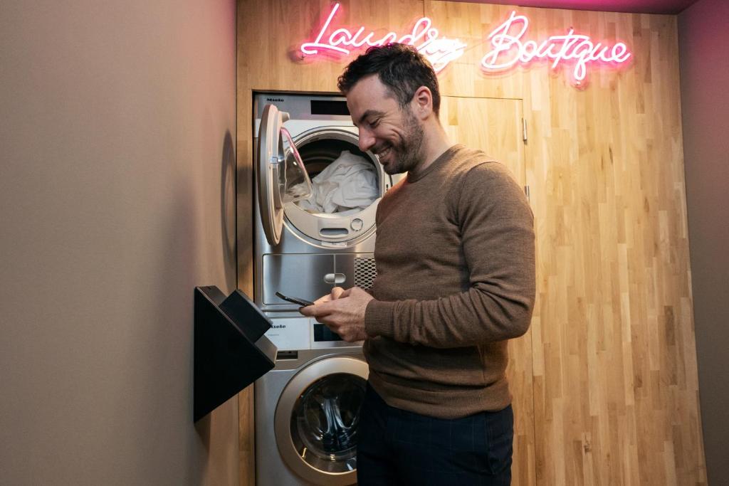 einem Mann, der vor einer Waschmaschine steht in der Unterkunft The Elephant Hostel in Amsterdam