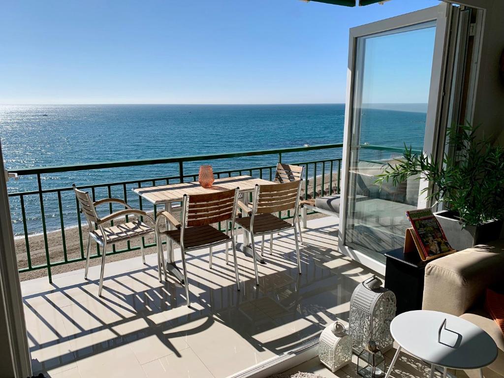 a balcony with a table and chairs and the ocean at Beachfront Apartment In Fuengirola in Fuengirola