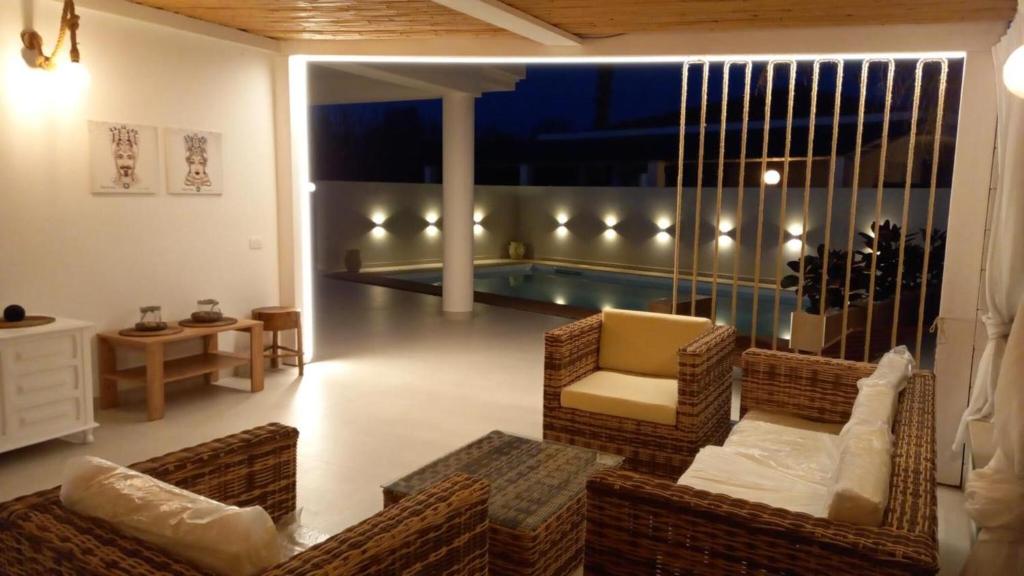 sala de estar con sillas y piscina en Villa Casa Giò, en Santa Maria del Focallo