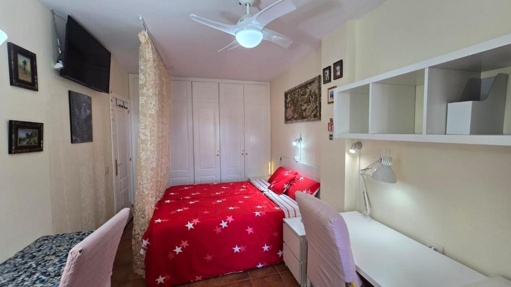 a bedroom with a red bed and two chairs at Tenerife cerca del aeropuerto in San Isidro