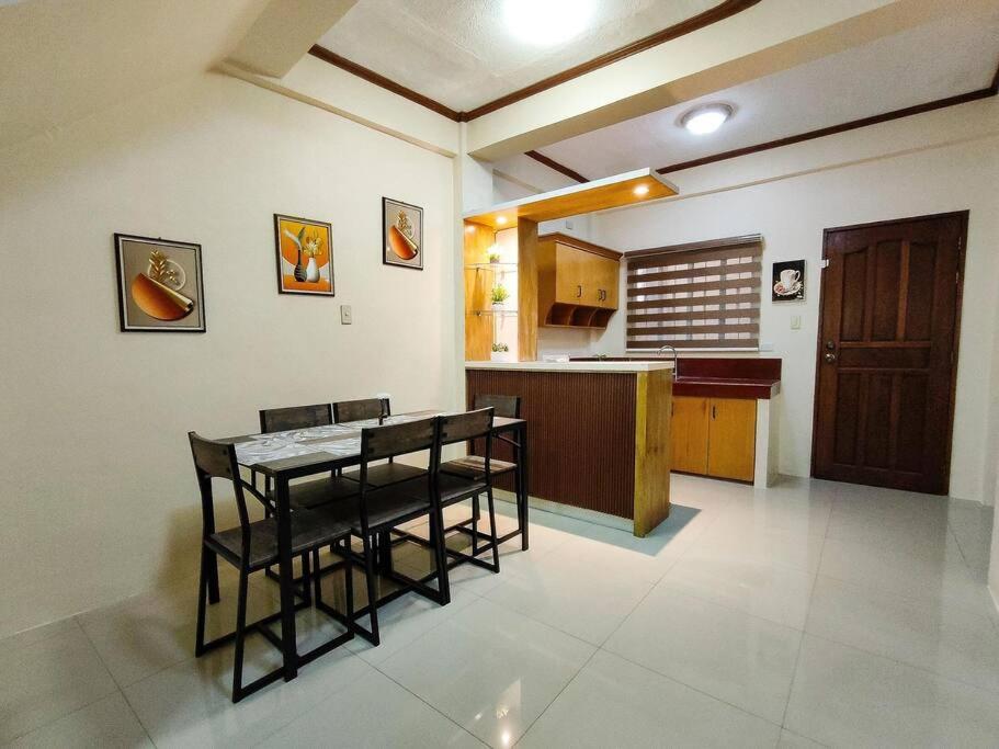 a kitchen with a table and chairs in a room at Spacious Apartment near Evia Daang Hari in Manila
