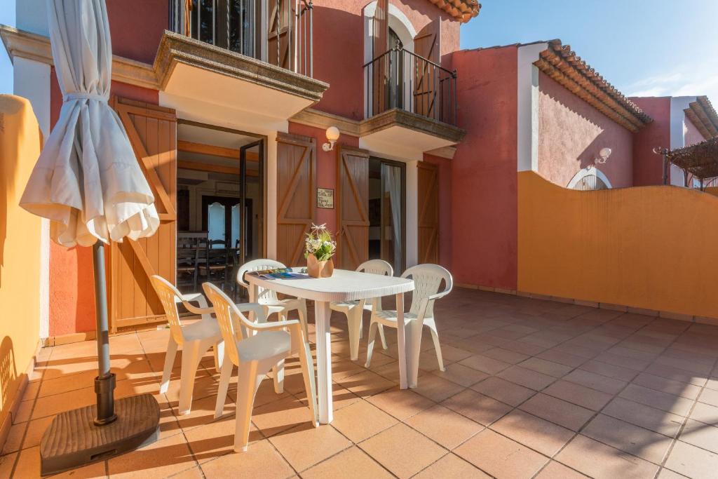 - une terrasse avec une table et des chaises blanches dans un bâtiment dans l'établissement 28 Maria Levy's, à Saint-Tropez