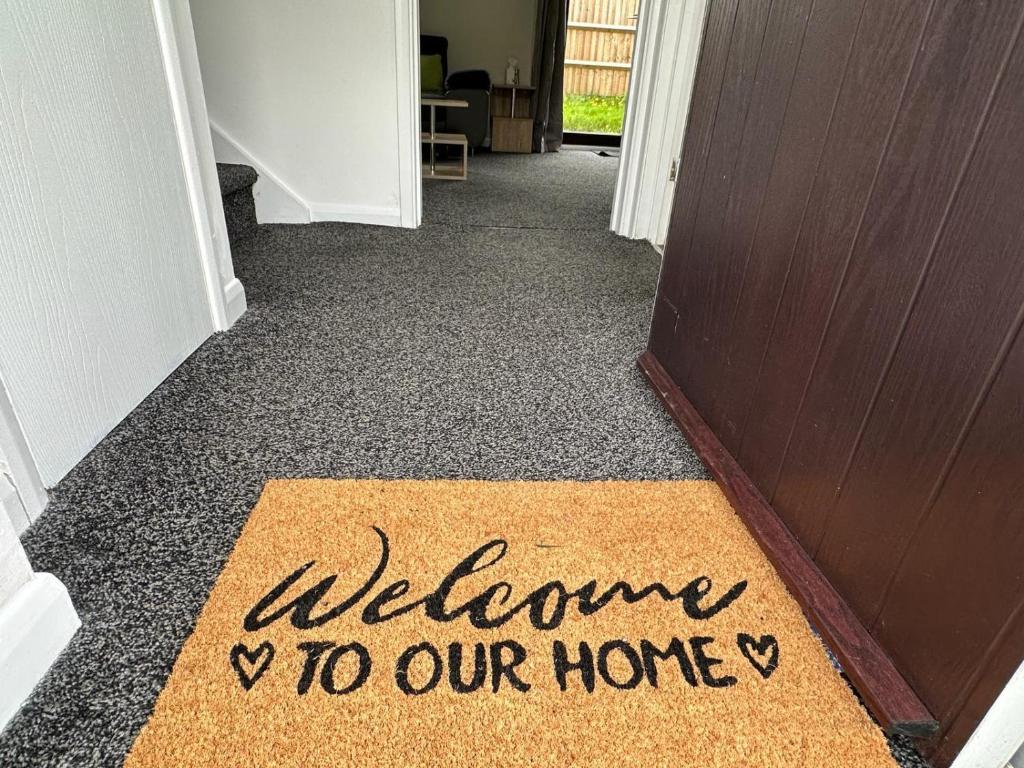 a welcome door mat with the words welcome to our home at Homely Milton Keynes Stay! in Milton Keynes