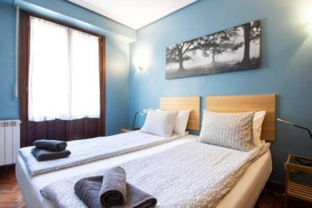 a bedroom with two beds with blue walls at Ubicación excelente para explorar la región in Villabona