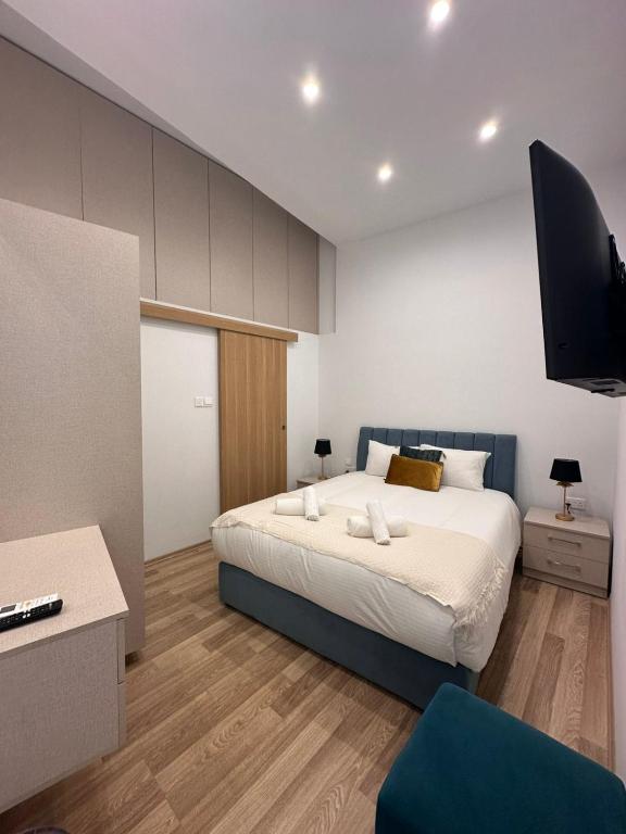 Un dormitorio con una cama y un televisor de pantalla plana. en Joanna's Rooms, en Kalopanayiotis