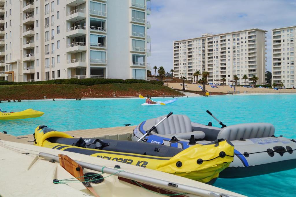 a yellow and blue boat in the water next to buildings at Laguna Bahia Fernanda in Algarrobo