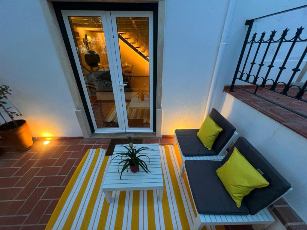 a patio with a couch and a table and a window at Casas dos Netos in Rio Maior