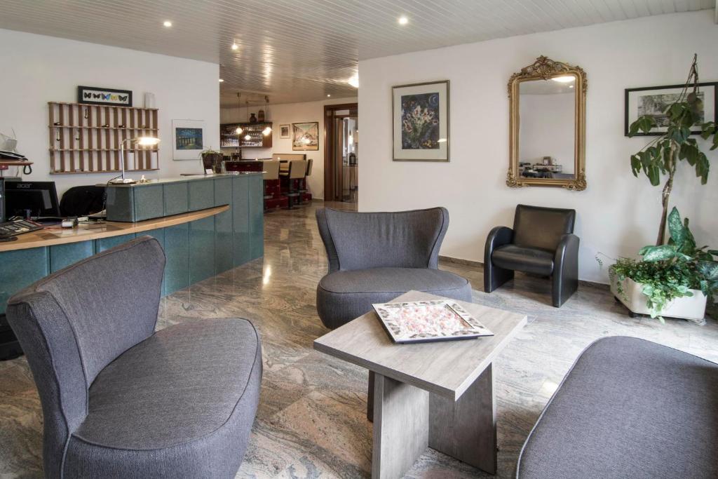 - une salle d'attente avec des chaises et une table dans l'établissement Hotel Maurer, à Karlsruhe