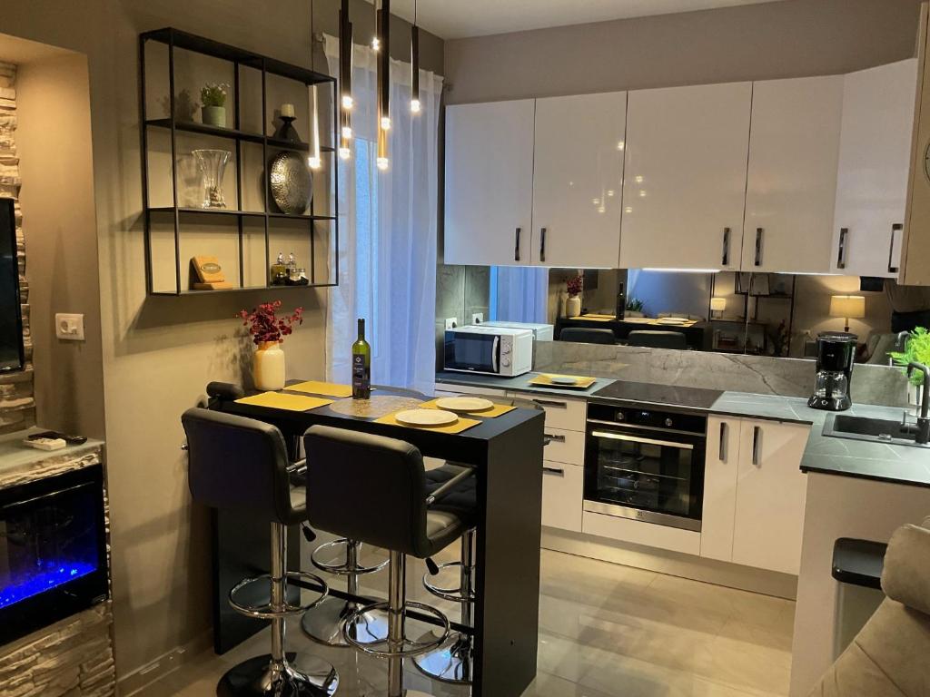 eine Küche mit weißen Schränken und einer schwarzen Insel in der Unterkunft BELLA CAMPAGNA - Luxury Two Bedroom Apartment in Rovinj